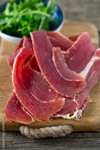 jamon and rucola on wooden surface