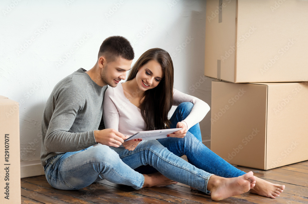Young couple unboxing in their new home Young couple unboxing in their new home