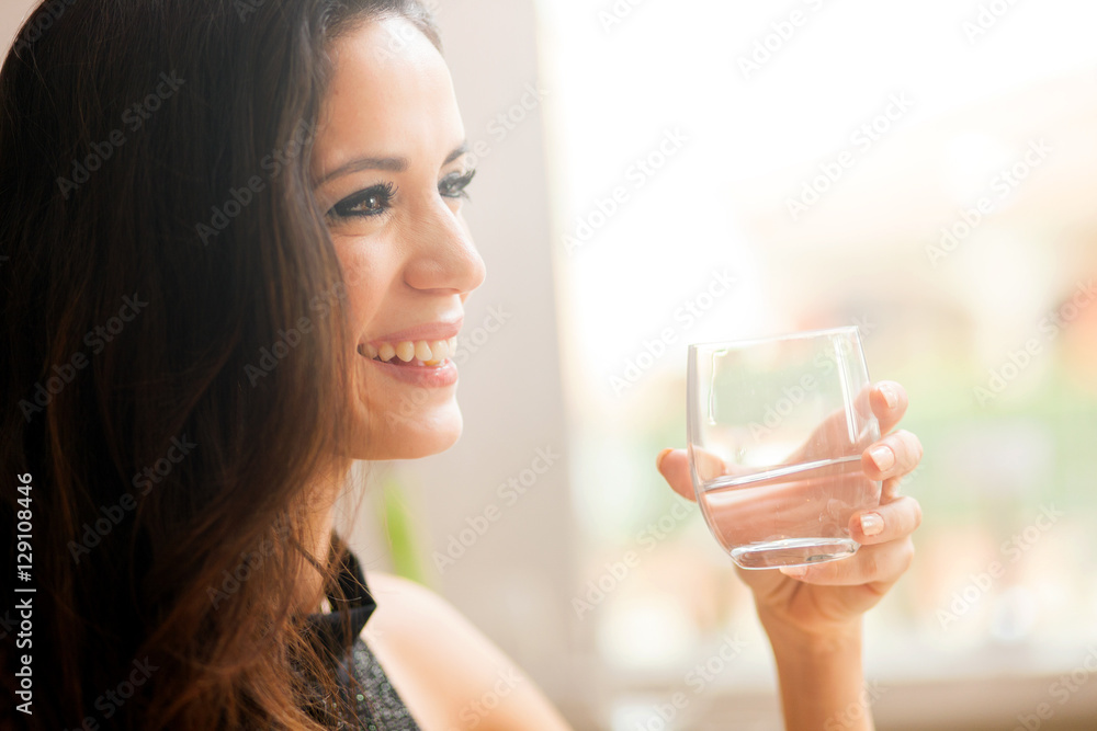 Beautiful young lady drinking water in restaurant Beautiful young lady drinking water in restaurant
