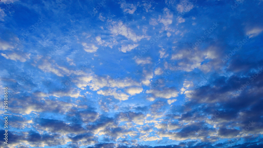 Fototapeta premium Chmury jasne i ciemne na niebieskim niebie.