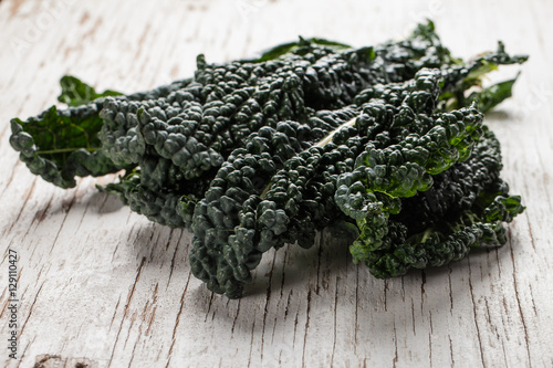 Horizontal shot of organic lacinato kale on white table photo