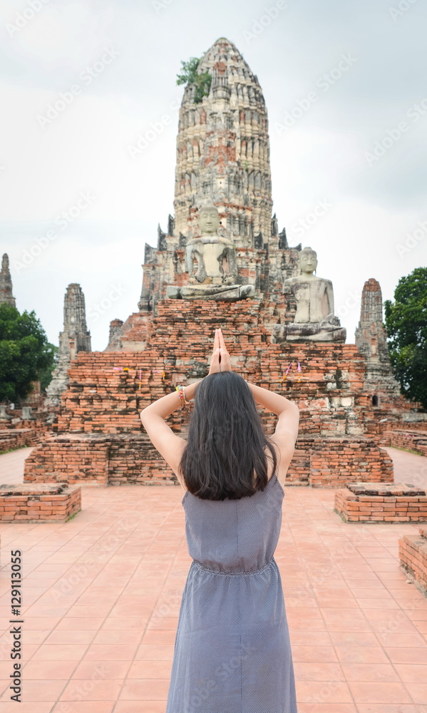Woman praying in front of Buddha in Ayutthaya Thailand