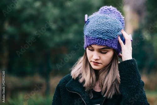 Thoughtful young woman in woolen violet blue cap