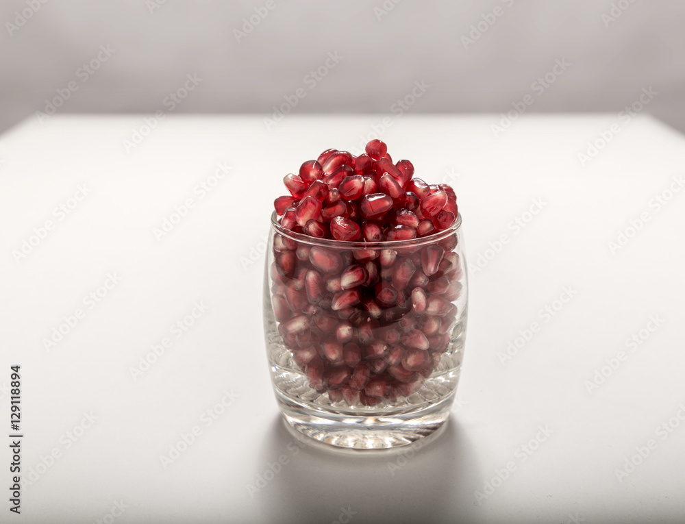Fresh red pomegranate seeds sprinkled in a glass Fresh red pomegranate seeds sprinkled in a glass
