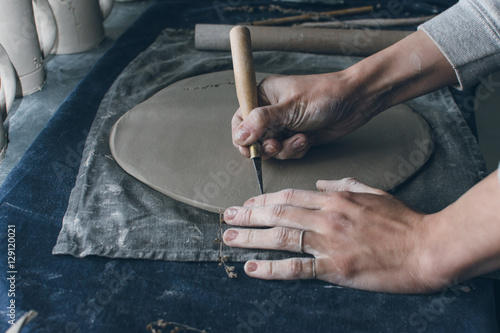 Woman hands using rolling pin, ceramic dish