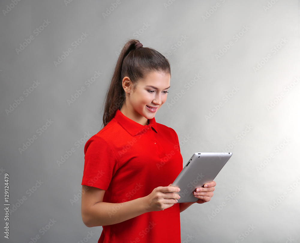 Beautiful young woman with tablet computer on light background Beautiful young woman with tablet computer on light background