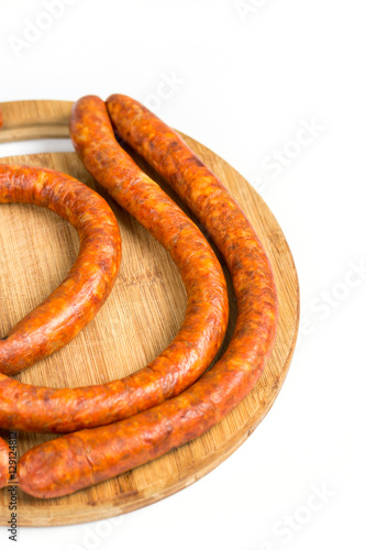 Raw homemade domestic sausage on the wooden board. Isolated over