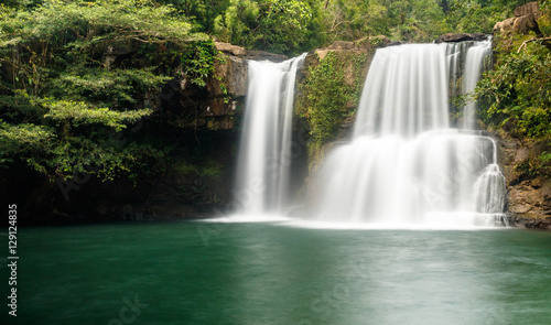 Fototapeta Naklejka Na Ścianę i Meble -  Klong Chao waterfall serenely cascades into the tranquil green pool below. It is located in the interior of the island of Koh Kood, Thailand.
