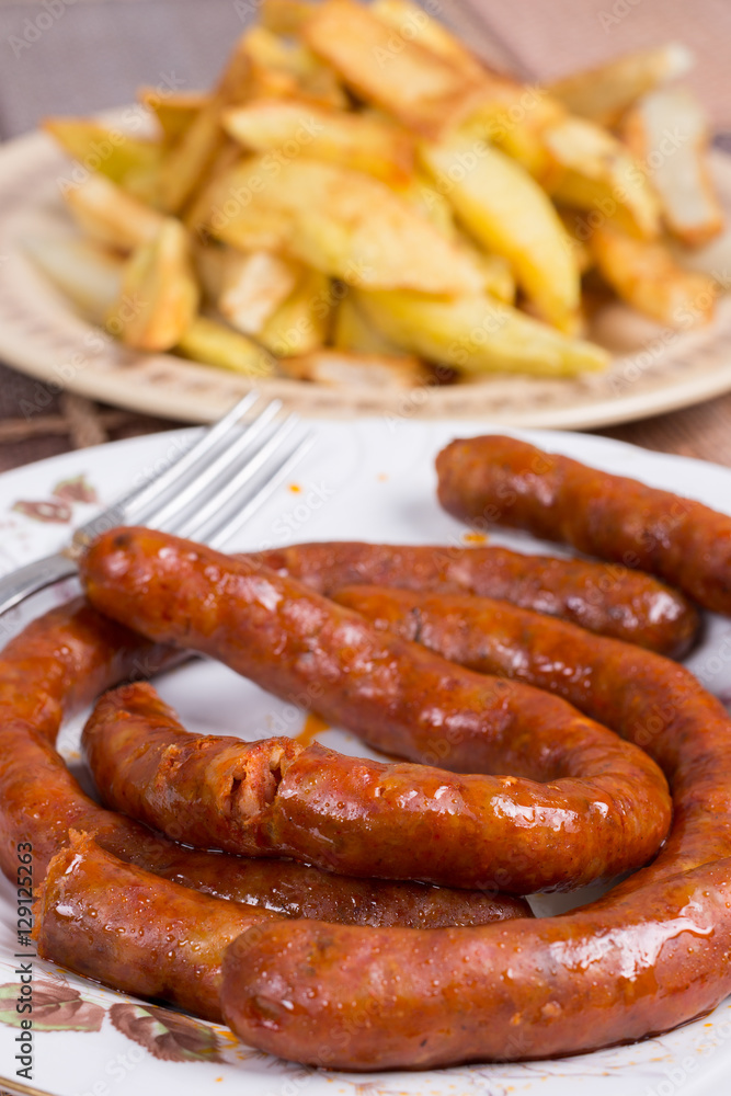 Raw domestic red sausages with fried potatoes Raw domestic red sausages with fried potatoes
