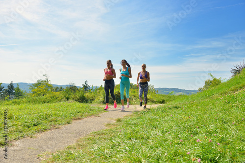 Three Female Joggers running together outdoors