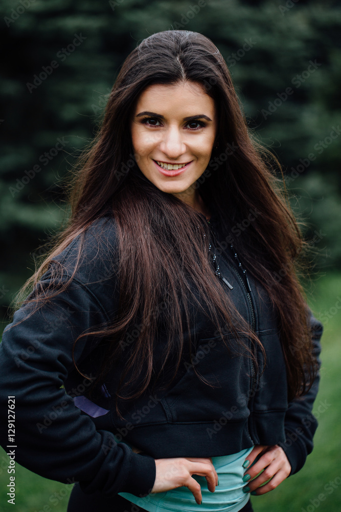 Beautiful fitness brunette athlete woman resting posing after work out exercising at park. Beautiful fitness brunette athlete woman resting posing after work out exercising at park.