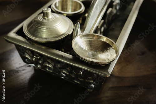 Malay heritage brassware, wedding equipment called Tepak Sireh over wooden background. shoot in low light and selective focus