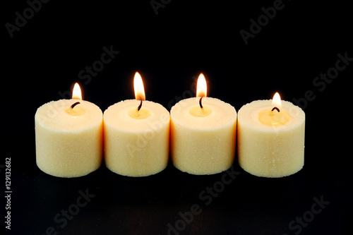 candle flame fire of white candles in a row on black background