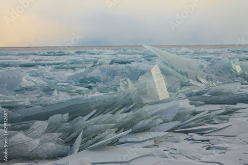 Foto Transparent Baikal ice hummocks at sunset in the fog