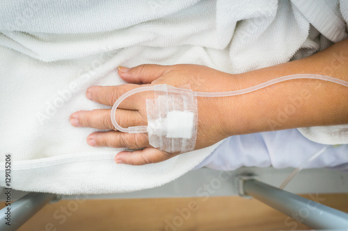 Close-up woman patient in hospital with saline intravenous (IV).