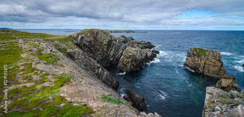 Cape Bonavista featuring coastal slabs of stone boulders and rocks that show their layers of formation over millions of years. Rocky boulder shoreline in Newfoundland, Canada.