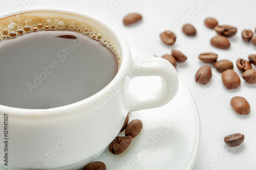 Close-up hot coffee with beans on light background