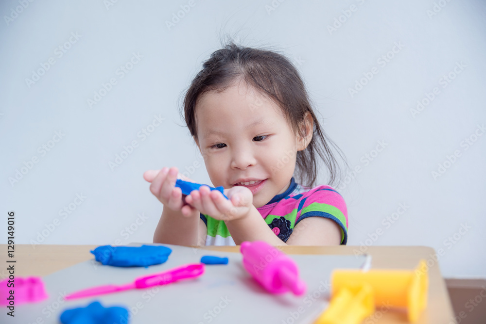 Little asian girl playing with dough on table Little asian girl playing with dough on table
