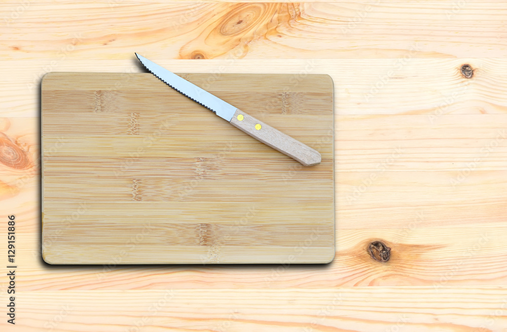 Empty bamboo cutting board and knife on a new wooden table for product display.Top view