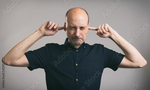 Man covering his ears