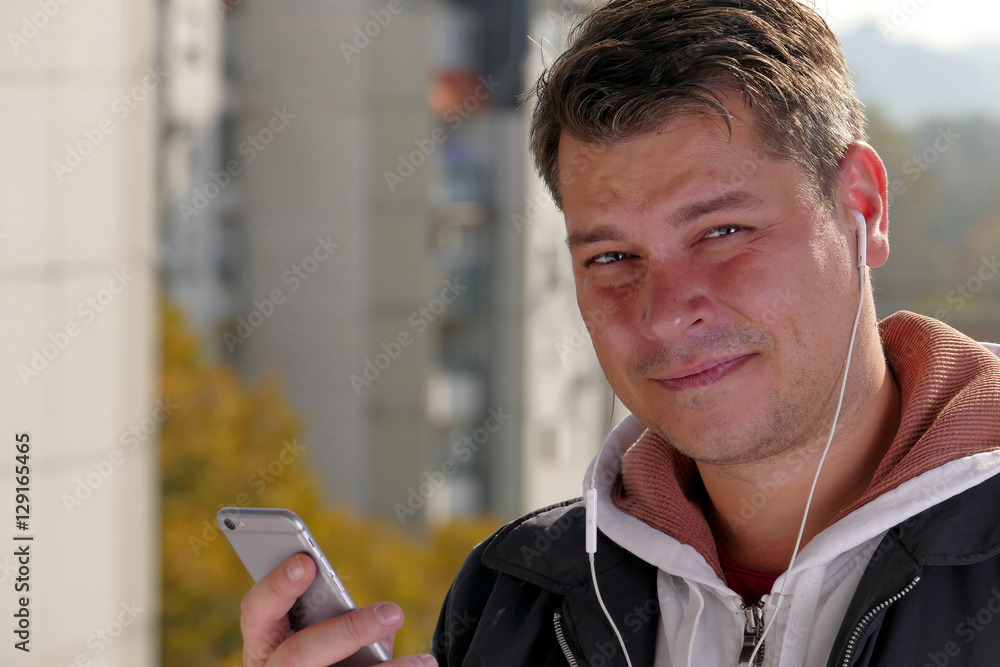 Man using smartphone on balcony during the sunny day Man using smartphone on balcony during the sunny day