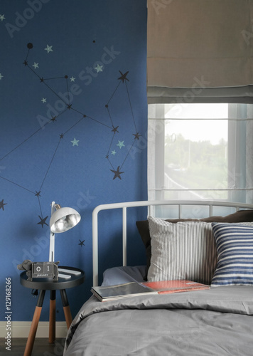 Beige and striped pillow on modern style bed setting and the blue wall bedroom