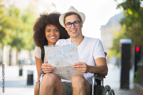 Photos disabled man and girlfriend tourists consulting map of city