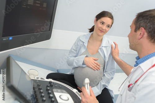 doctor showing pregant woman ultrasound photo