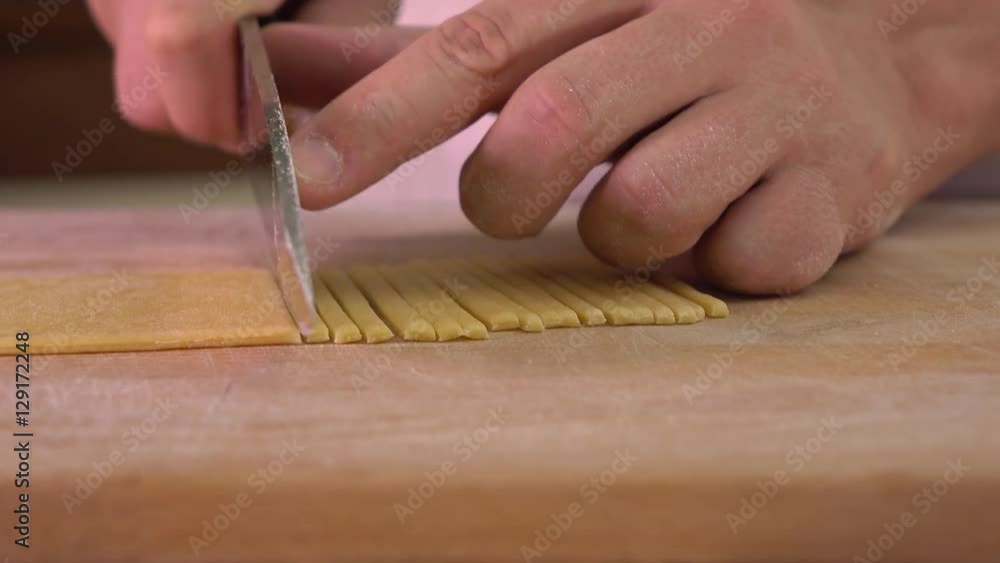Man cutting homemade pasta with a knife. Amateur cooking at home. 4K close up steadicam video Man cutting homemade pasta with a knife. Amateur cooking at home. 4K close up steadicam video