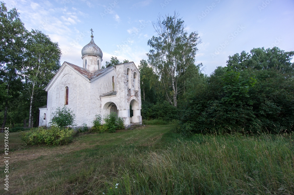 Orthodox Church and nature. Green garden and architecture. Under the blue sky a house which is surrounded by a beautiful natural environment. Trees, bushes and building - Piirissaar, Estonia, Europe.