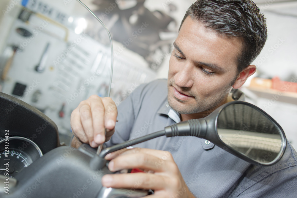 Obraz premium Repairing a customer's scooter