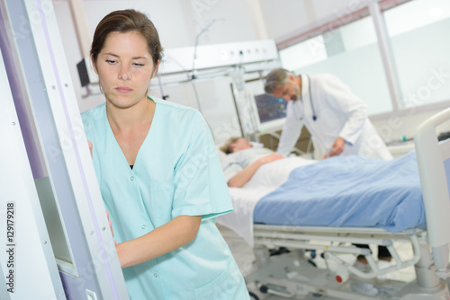 sad female nurse at hospital corridor