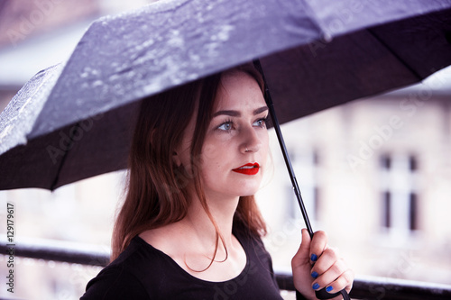 young brunette woman with umbrella in the rain