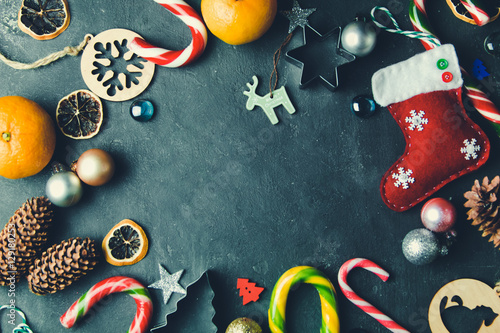 Beautiful Christmas background with Colorful candy, decor, toys and tangerines on dark background