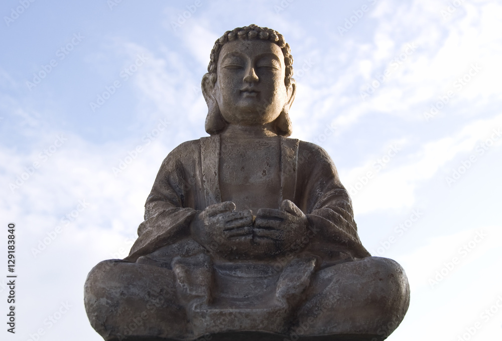 Fototapeta premium Sitting Buddha image on blue sky background.