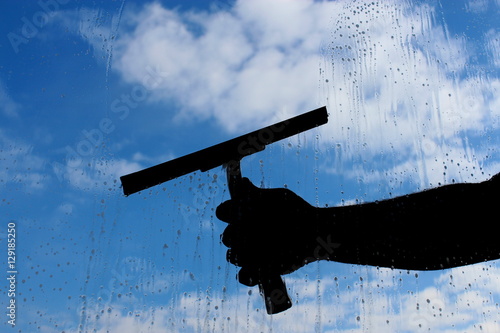 man cleaning the window with cloudy background photo