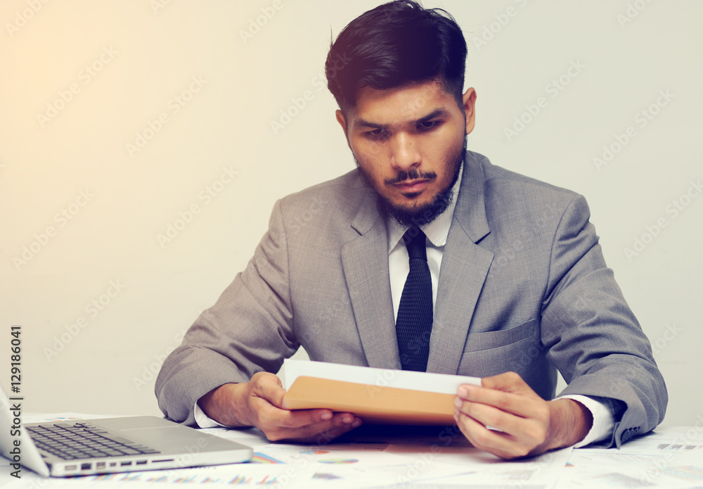 Young businessman opening business report document Young businessman opening business report document