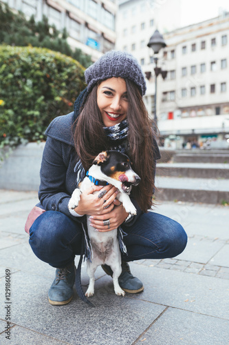 Beautiful brunette young woman holding her adorable Jack Russel terrier.  photo