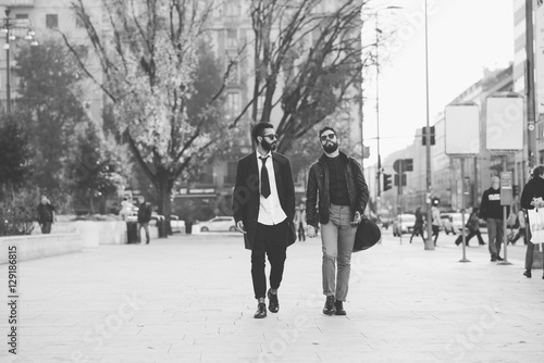 Two young bearded blonde and black hair modern businessman, walking in the city talking to each other - working, successful concept - black and white © Eugenio Marongiu