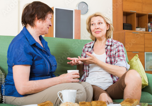 Two mature female drinking tea