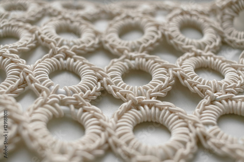 Close-up of braided cord pattern rings on white textured backgro