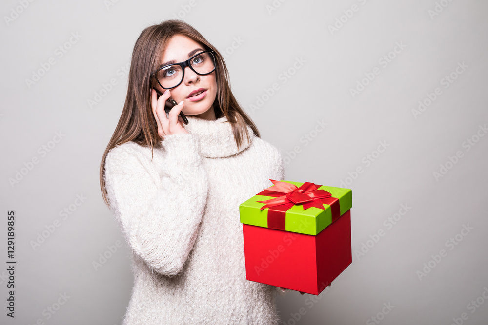 Girl speak on phone with present in hand Girl speak on phone with present in hand