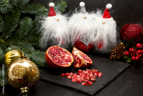 ripe omegranate and Christmas decoration photo