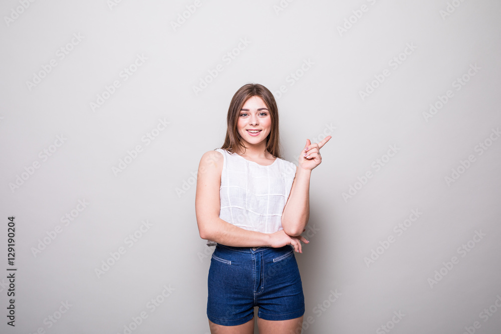 girl pointing finger up at copyspace isolated on a gray background girl pointing finger up at copyspace isolated on a gray background
