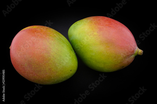 Mango of green and red color on a black background closeup