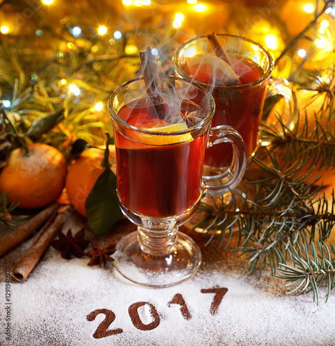 2017 New Year.Mulled wine with spices and tangerines on wooden background