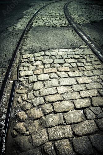Dark cobblestone and old train track rails
