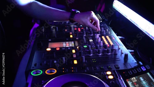 DJ mixing console,Dj mixes the track in the nightclub at party. hands in motion