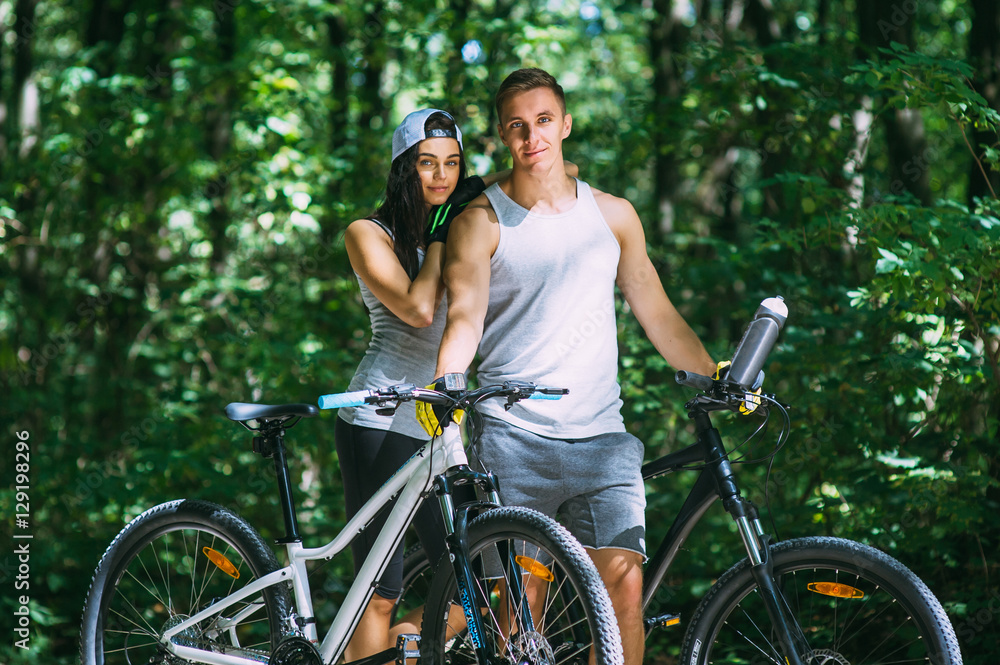 Obraz premium Young Couple Riding Bike In Park