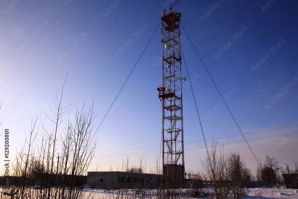 white-red telecommunication tower on blue sky background